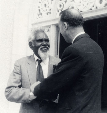 Uncle Fred Murray smiling at Collis Featherstone as they clasp each other's hands.